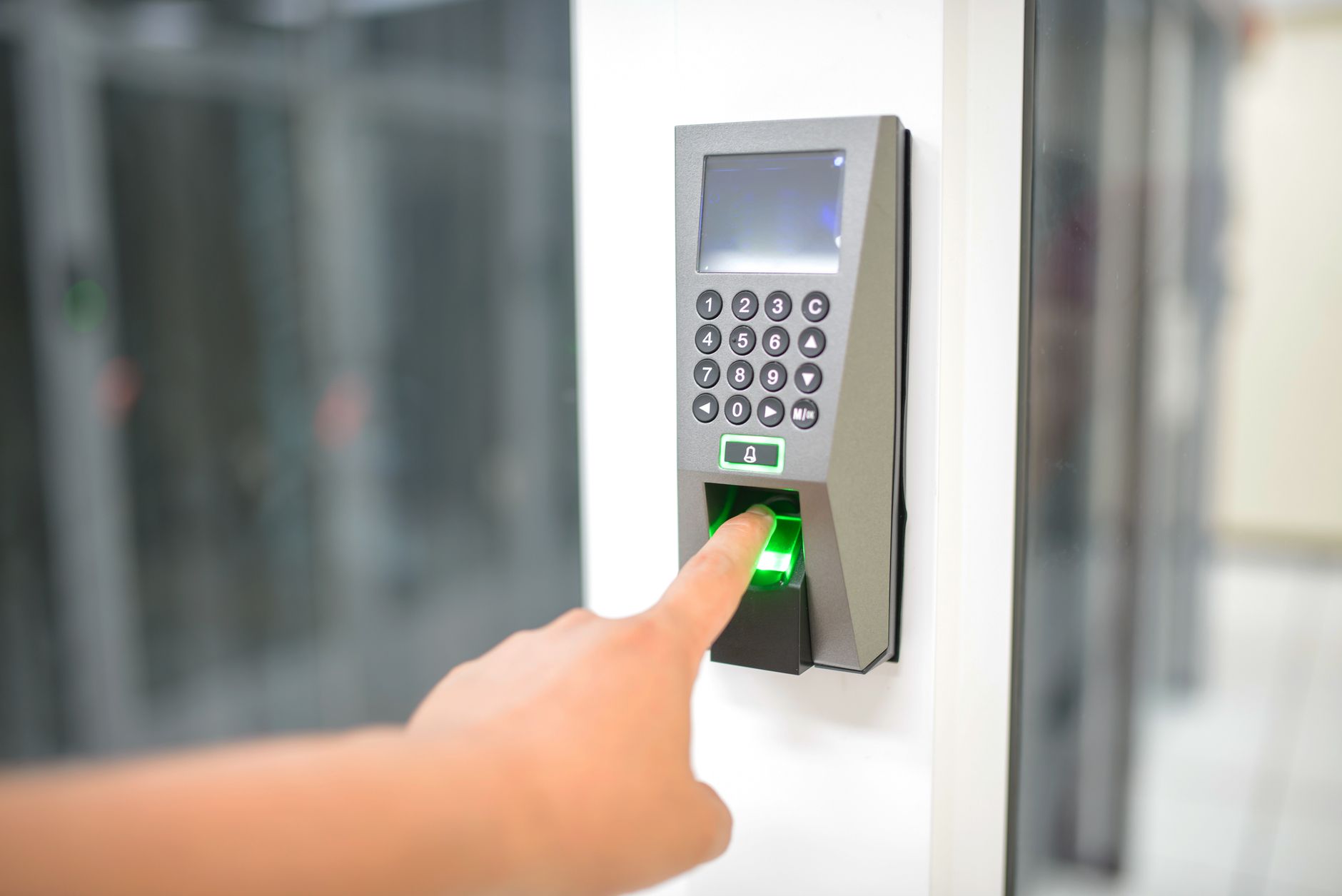 Close-up of a glowing fingerprint scanner on a dark security panel