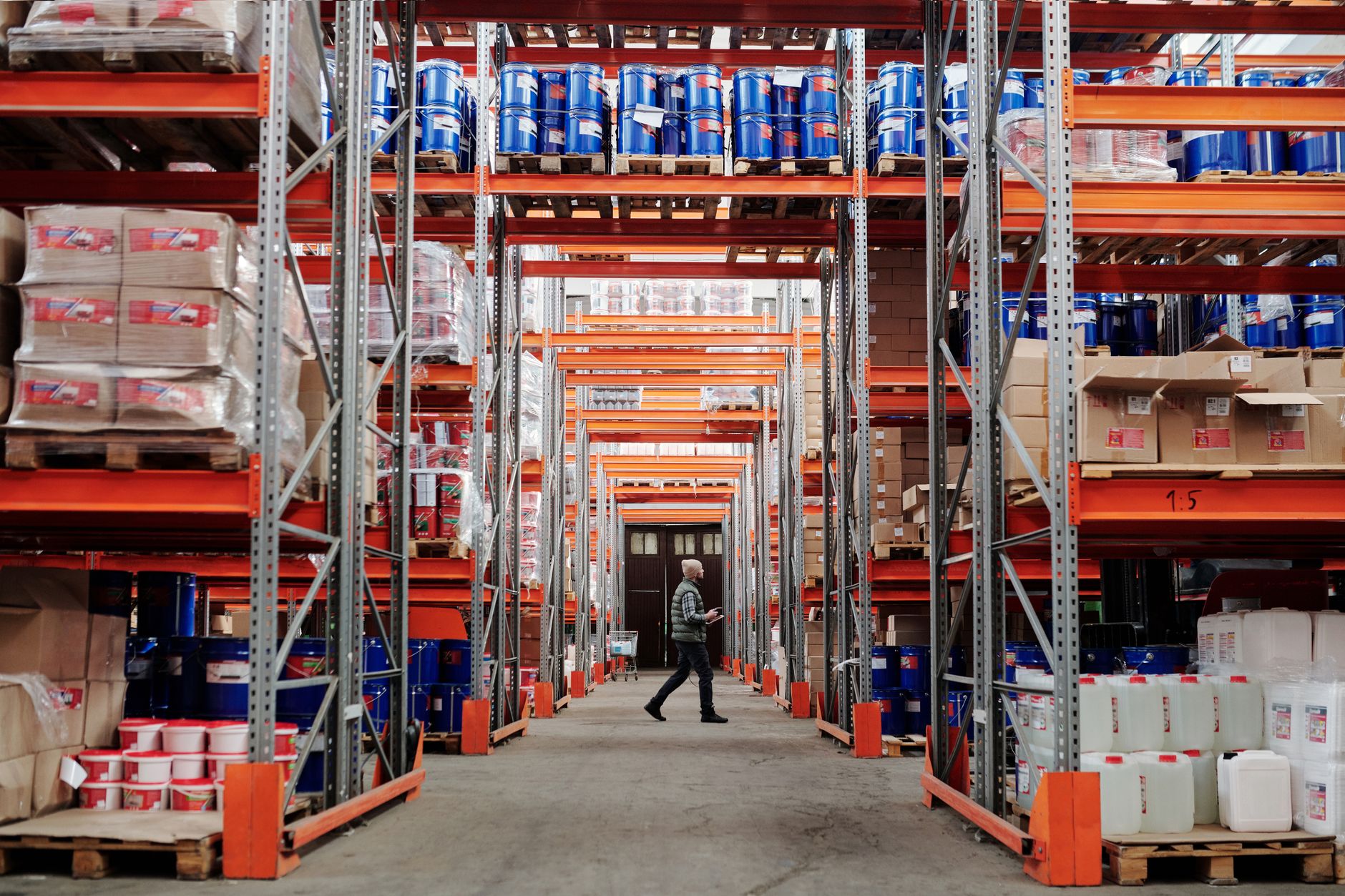 A long, brightly lit aisle between server racks in a data center