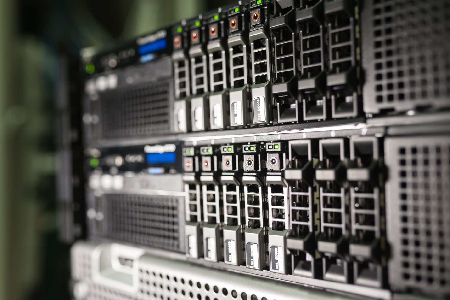 Rows of hard drive bays in a storage server rack with green status lights