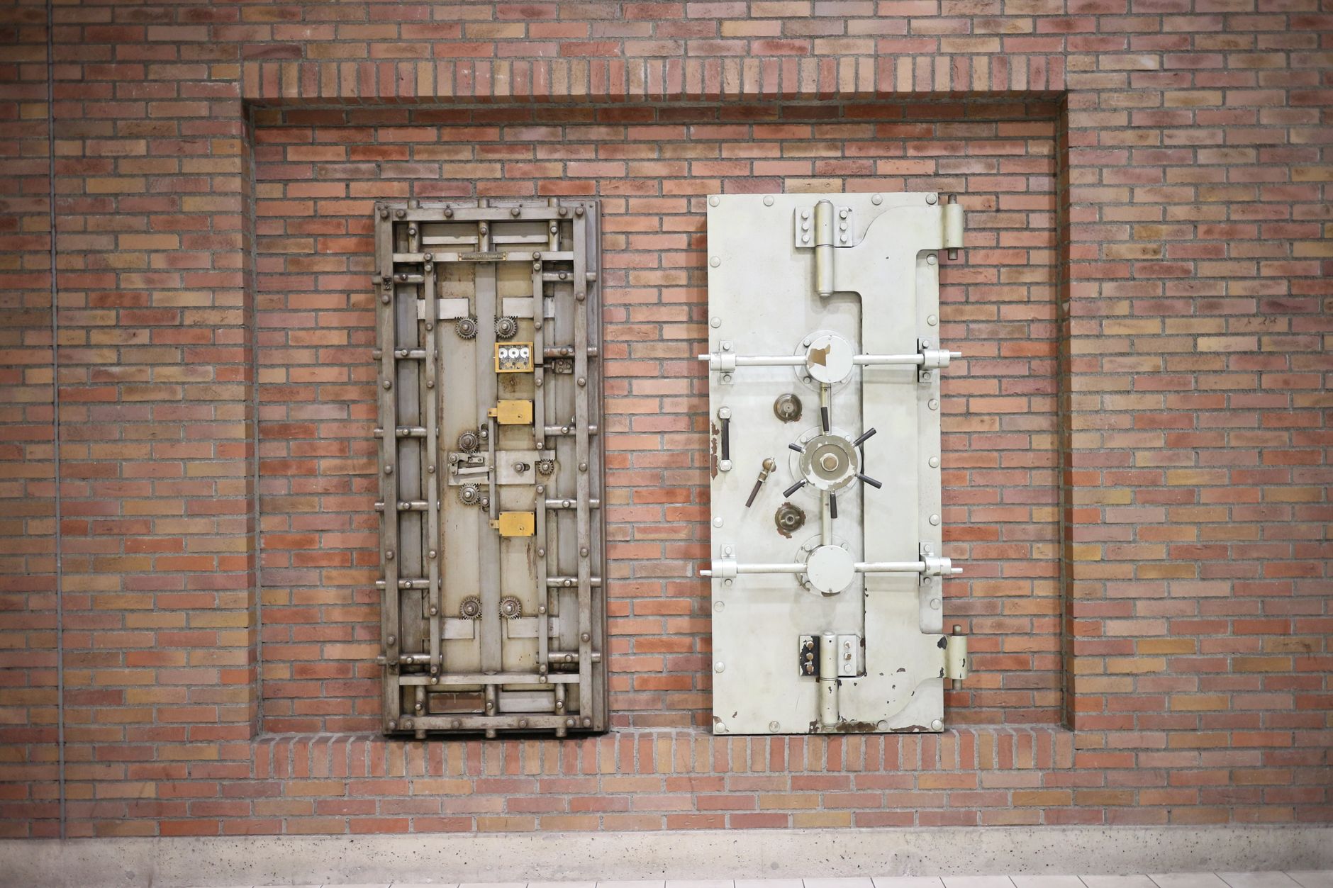 A heavy round steel vault door standing open in a bright room