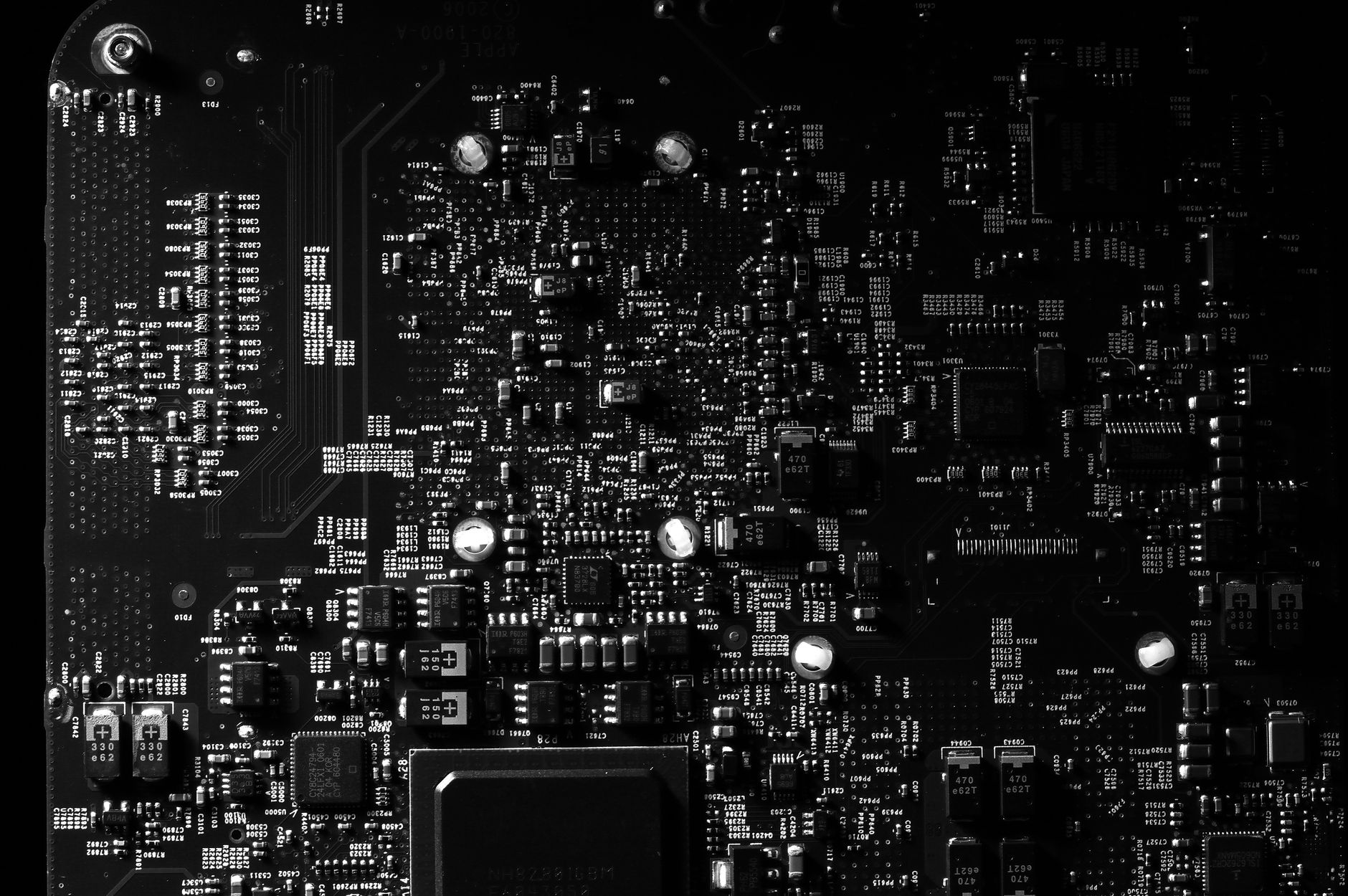 A metal padlock resting on a green printed circuit board
