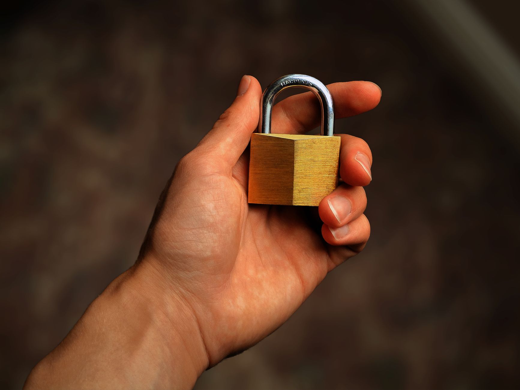 A small metal padlock resting on the keys of a dark laptop keyboard