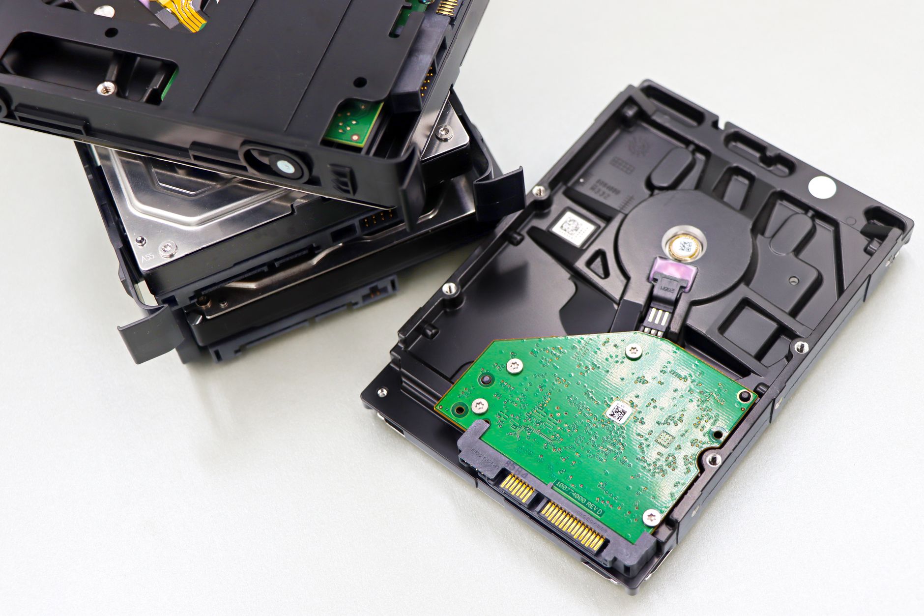 A stack of hard disk drives on a desk under cool blue light